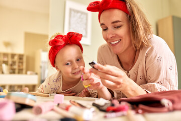Mother and daughter enjoying quality time together experimenting with makeup