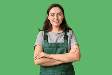 Young female construction worker on green background. Woman in male profession concept