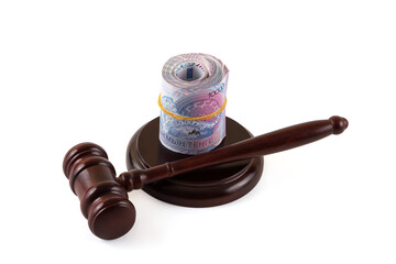 Banknotes of 10,000 Kazakhstani tenge and a judge's gavel on a white background