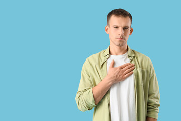 Apologizing young man on blue background