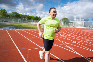 Determined man running on track, embracing fitness journey for health and well-being