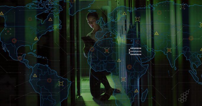 Kneeling technician monitoring racks in data center holding tablet displaying world map overlay