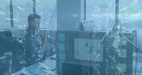 Analyzing worker in button-down shirt studying data flow at cubicle, with monitor, lamp, copy space