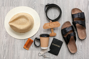 Traveler's accessories with toy airplane on light wooden floor, top view