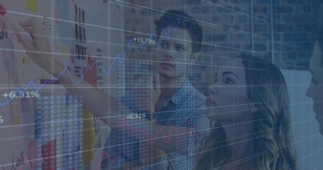 Pointing office professionals in business attire at whiteboard, with charts and sticky notes