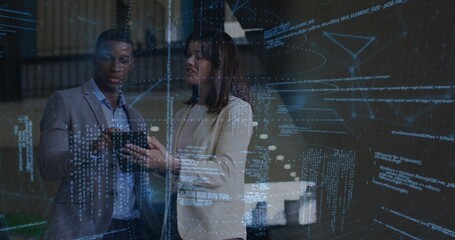 Colleagues in blazers reviewing code on tablet in office with holographic overlays and data visuals