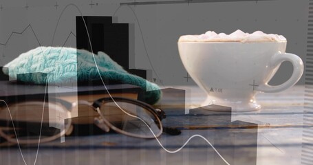 Presenting white cup of coffee on cafe table with book, glasses, teal cloth, charts, copy space