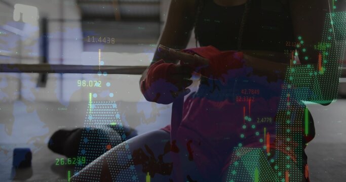 Tying female athlete winding red hand wraps around fist in gym, with barbell rack, digital overlay