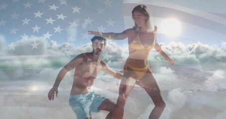 Riding surfboard on ocean wave, couple in swimwear with US flag and clouds overlay