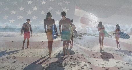 Walking group of six surfers carrying surfboards toward ocean on sandy shore, with flag overlay