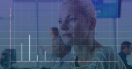 Analyzing woman examining bar and line chart grid at office desk, with computer monitors