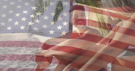 Naklejka premium Sitting couple in swimwear facing each other on sand under palm fronds, with American flag overlay