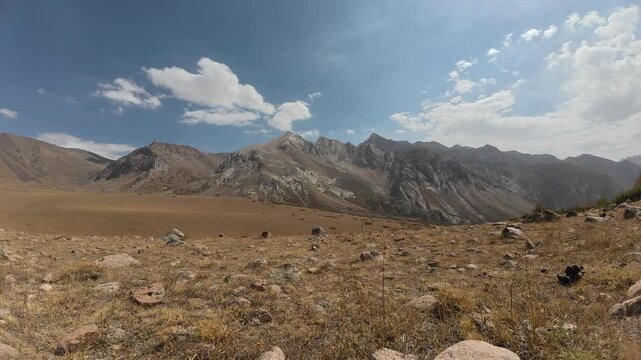 Timelapse of cloudy sky with an overview of Sairam peak, at an altitude of 2800 meters above sea level in the Valley of Ancestors, mountains of Sairam-Ugam National Park in the Republic of Kazakhstan.