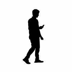 Silhouette of a person walking while looking at their mobile phone