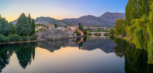 Serenity at dusk in Trebinje by the river, showcasing nature's beauty and architectural charm