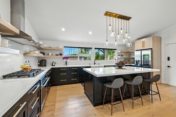 Bright modern kitchen with center island, pendant lighting, and open concept design in a luxury home