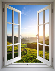 Open window revealing rolling green hills and golden sunrise rolling hills green landscape