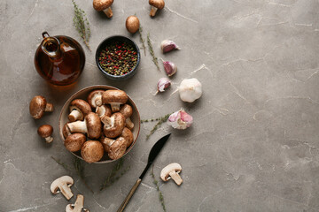 Bowl with fresh raw mushrooms, peppercorns and thyme on grey background