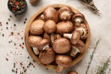 Wooden plate with fresh raw mushrooms, thyme and peppercorns on white background