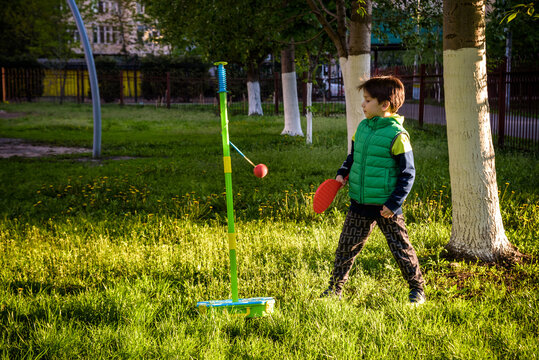Happy boy is playing tetherball swing ball game in summer camping. Happy leisure healthy active time outdoors concept