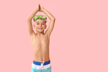 Cute little boy with flippers and snorkelling mask in starting position on pink background © Pixel-Shot