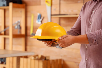 Man holding hardhat in workshop