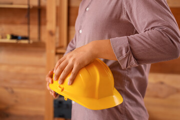 Man holding hardhat in workshop