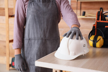 Man with hardhat on table in workshop
