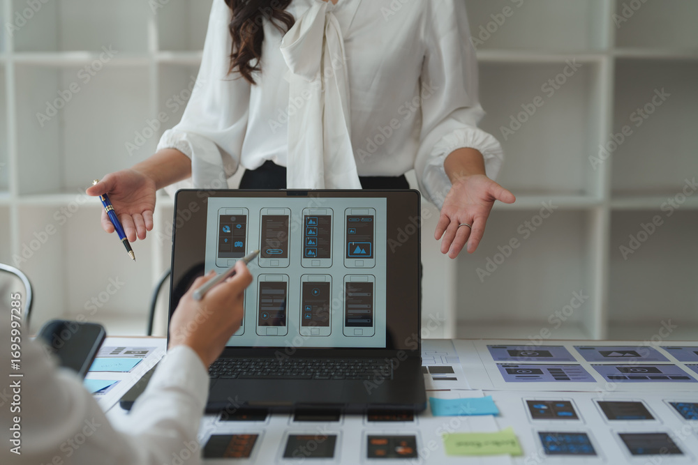 Aufkleber ux ui designers discussing mobile app interface design on laptop