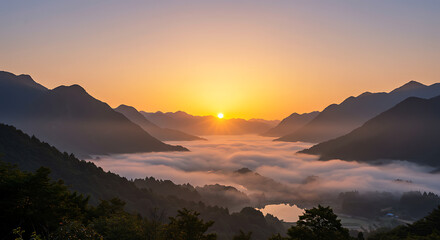 Ethereal morning light as the sun rises over a majestic misty valley and a hidden lake