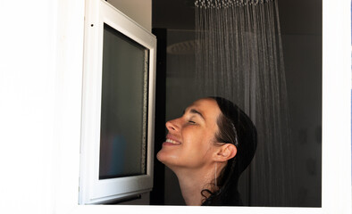 Smiling woman taking a shower and enjoying the moment of relaxation