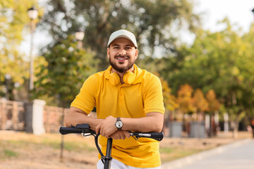 Handsome young man on electric scooter at city street
