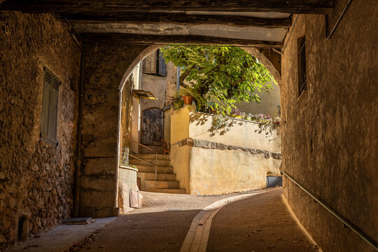Alley through an old archway with wooden beams in Salernes, Department Var, Provence, France