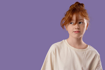 Portrait of cute teenage redhead girl on lilac background