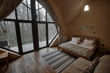 Cozy bedroom with large windows and a forest view