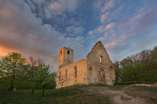 View of the weathered stone ruins of Katar&Atilde;&shy;nka Monastery rise against a sky ablaze with sunset hues, casting long shadows, Dechtice, Trnavsk&Atilde;&frac12; kraj, Slovakia.