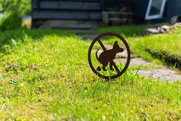 This is a prominently displayed Dog Restriction Sign that is placed in the lush green lawn area