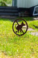 This is a prominently displayed Dog Restriction Sign that is placed in the lush green lawn area