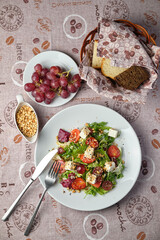 Fresh salad with grapes and bread on a table