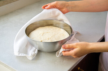 Woman Checking Rising Yeast Dough in Metal Bowl