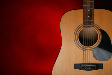 Obraz premium Modern acoustic guitar on red background, closeup