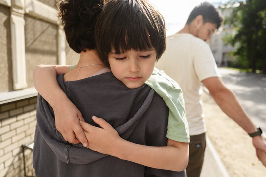 Mother and son hugging outdoors while walking in summer