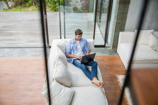 Freelancer working on laptop in living room at home