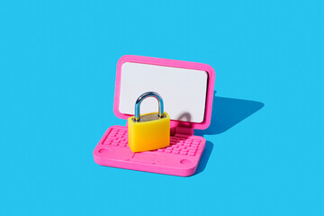 Yellow padlock on pink toy laptop symbolizing online security