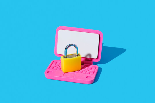 Yellow padlock on pink toy laptop symbolizing online security