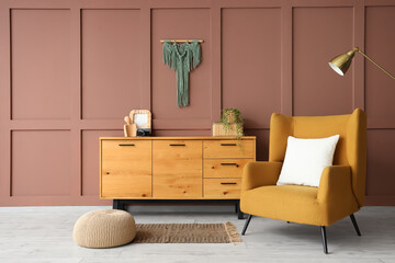 Interior of stylish living room with cozy brown armchair, standard lamp and wooden cabinet