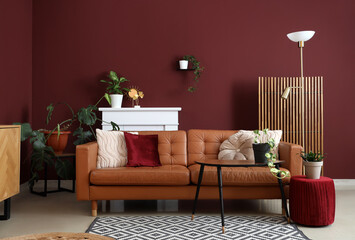 Interior of modern living room with cozy brown sofa, coffee table, ottoman and fireplace