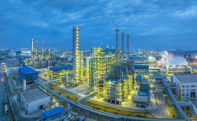 Fototapeta premium Large oil refinery and petrochemical plant with illuminated equipment and pipelines at night.