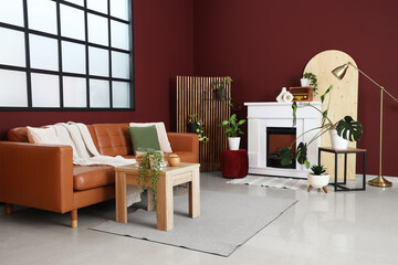 Interior of stylish living room with cozy brown sofa, wooden coffee table and fireplace