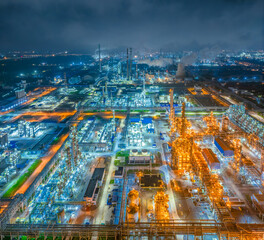 Large petrochemical plant and oil refinery complex brightly illuminated at night.